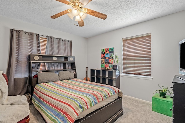 bedroom with baseboards, carpet, a ceiling fan, and a textured ceiling