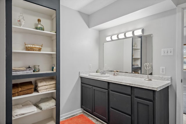 bathroom with vanity, built in features, and baseboards