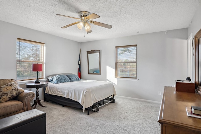 bedroom with ceiling fan, baseboards, carpet floors, and a textured ceiling