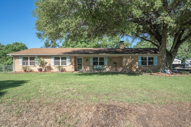 ranch-style house with a front lawn, brick siding, and a chimney