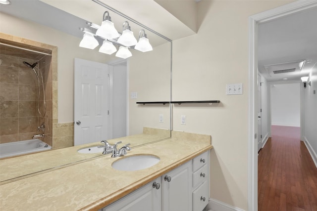 bathroom with shower / bathtub combination, baseboards, wood finished floors, and vanity