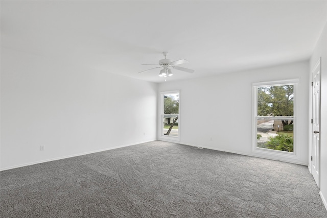 carpeted spare room featuring baseboards and ceiling fan