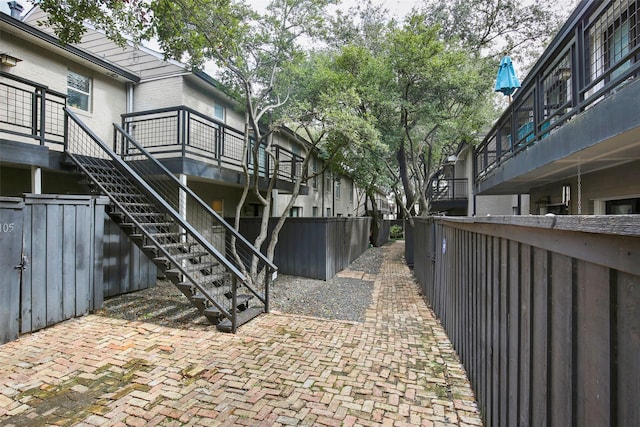 view of patio with stairs and fence