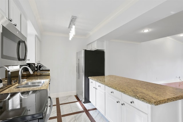 kitchen featuring white cabinetry, stainless steel appliances, crown molding, and baseboards