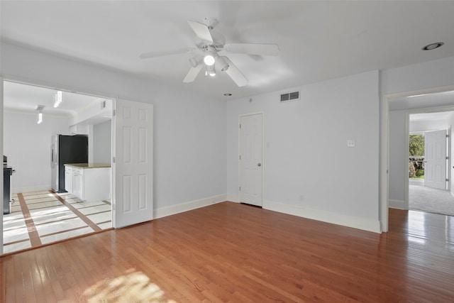 unfurnished living room featuring visible vents, baseboards, light wood-style floors, and a ceiling fan