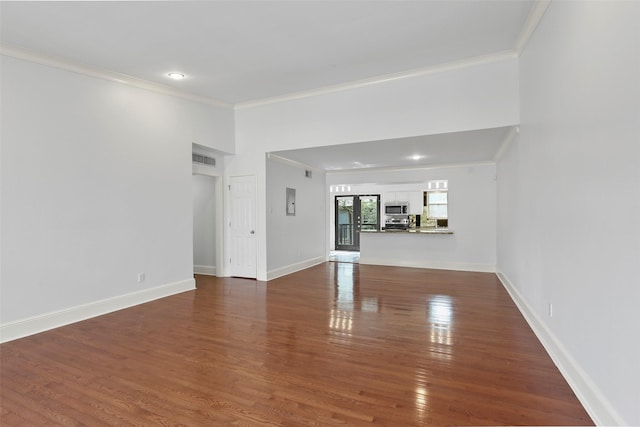 unfurnished living room featuring visible vents, dark wood-type flooring, baseboards, ornamental molding, and recessed lighting