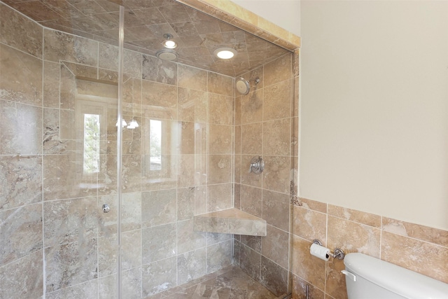 full bath featuring tiled shower and toilet