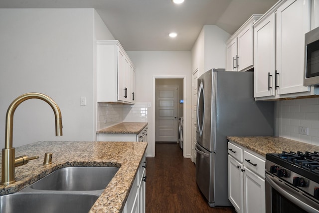 kitchen with dark wood-style floors, white cabinets, stainless steel appliances, and a sink