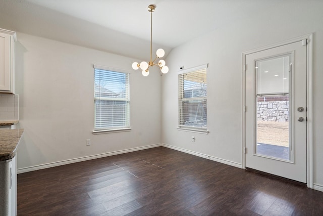 unfurnished dining area featuring a notable chandelier, baseboards, and dark wood-style flooring