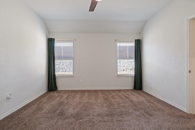 carpeted empty room featuring a wealth of natural light, baseboards, lofted ceiling, and ceiling fan