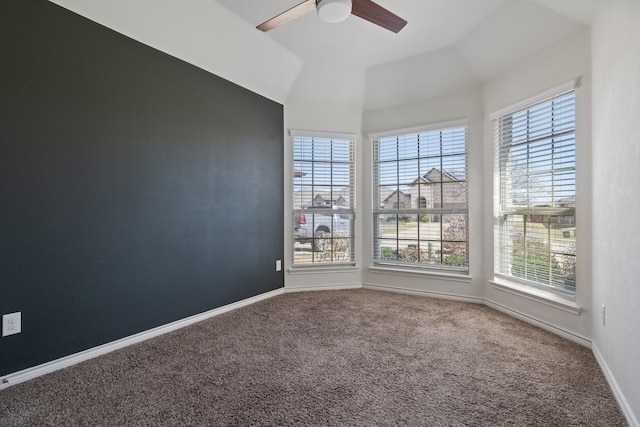 carpeted spare room featuring lofted ceiling, a ceiling fan, and baseboards