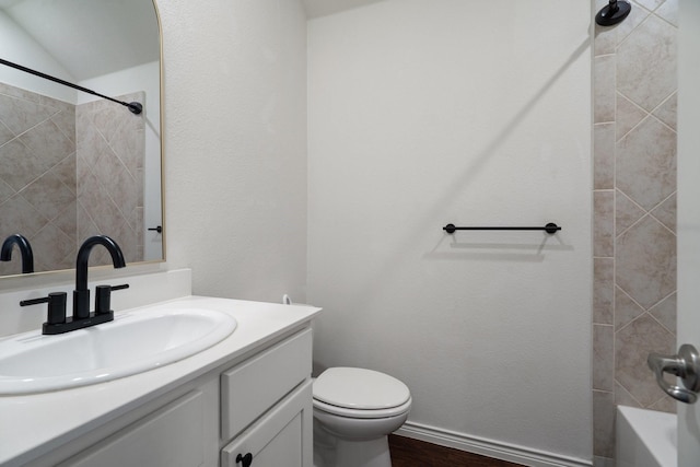 bathroom with baseboards, toilet, wood finished floors, and vanity