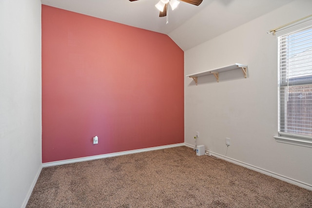 carpeted spare room featuring vaulted ceiling, baseboards, and ceiling fan