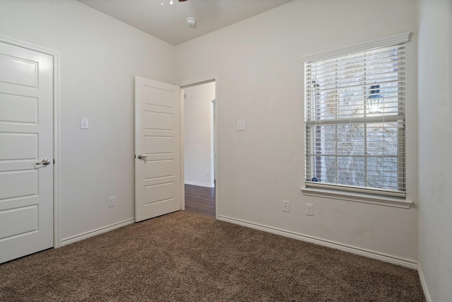 unfurnished bedroom featuring carpet flooring, multiple windows, and baseboards