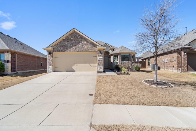 view of front of property featuring a garage, cooling unit, brick siding, and concrete driveway