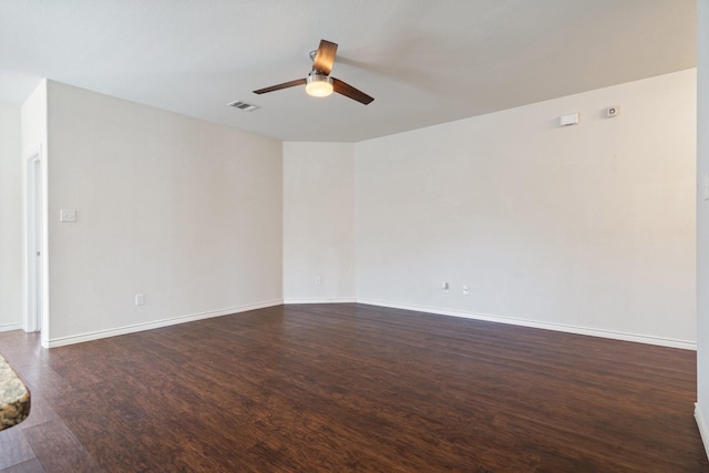 unfurnished room featuring ceiling fan, visible vents, dark wood-style flooring, and baseboards