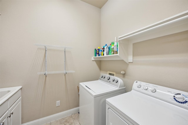 washroom with baseboards, cabinet space, light tile patterned flooring, and washer and clothes dryer