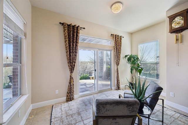 living area featuring light tile patterned flooring and baseboards