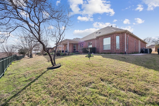 view of front of property with brick siding, a front lawn, and fence