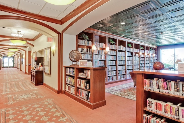 corridor with baseboards, arched walkways, ornamental molding, and carpet flooring