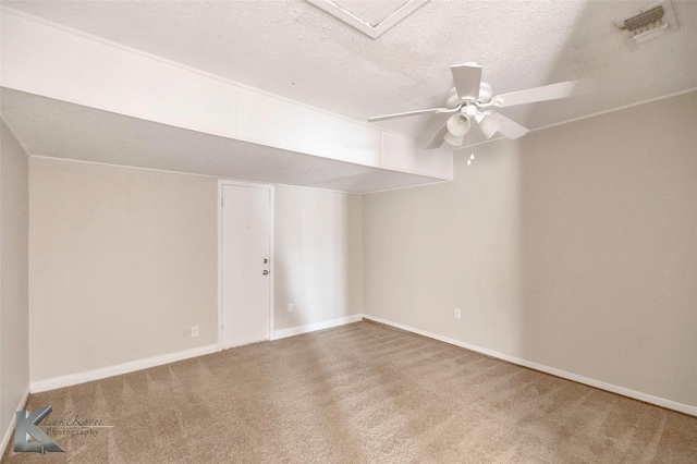 unfurnished room featuring a ceiling fan, baseboards, visible vents, a textured ceiling, and carpet flooring