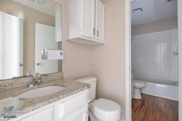 bathroom featuring visible vents, toilet, shower / tub combination, wood finished floors, and vanity