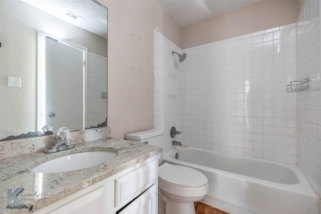 bathroom with visible vents, toilet, shower / tub combination, a textured ceiling, and vanity