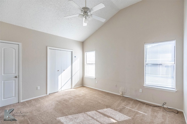 unfurnished bedroom featuring multiple windows, carpet flooring, and vaulted ceiling