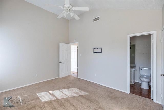 unfurnished bedroom featuring visible vents, connected bathroom, baseboards, carpet, and high vaulted ceiling