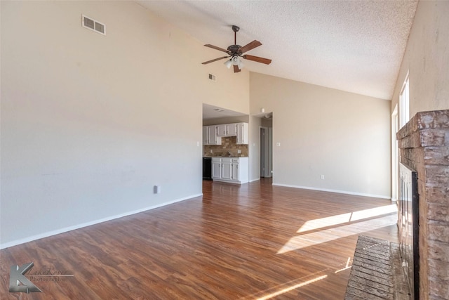 unfurnished living room with a fireplace, a textured ceiling, ceiling fan, and dark wood-style flooring