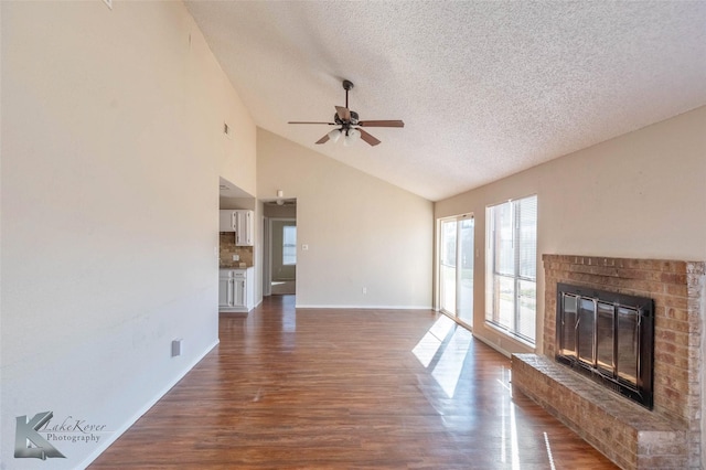 unfurnished living room featuring a textured ceiling, a fireplace, baseboards, ceiling fan, and dark wood-style flooring