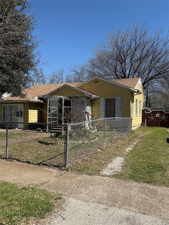 bungalow-style home with a fenced front yard, a carport, concrete driveway, and a front lawn