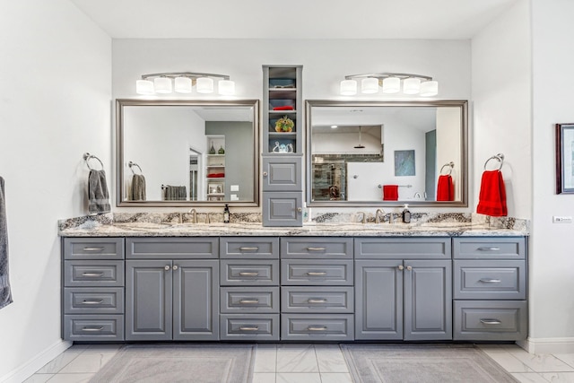 full bathroom with double vanity, baseboards, marble finish floor, and a sink