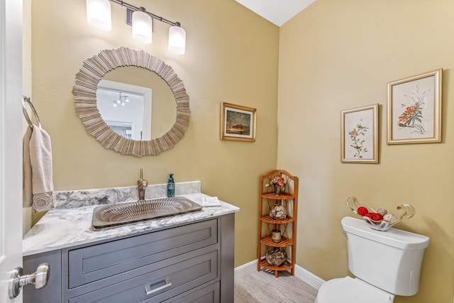 bathroom with vanity, toilet, and baseboards