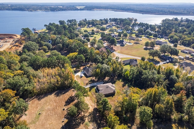 birds eye view of property with a water view and a wooded view