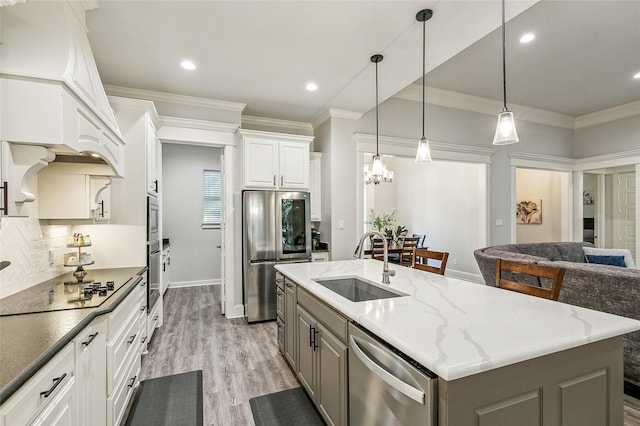 kitchen with light wood finished floors, gray cabinetry, ornamental molding, appliances with stainless steel finishes, and a sink