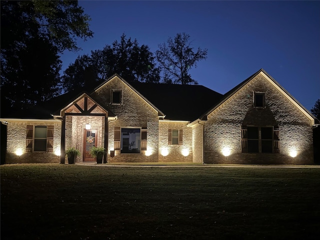 view of front facade with a yard and brick siding