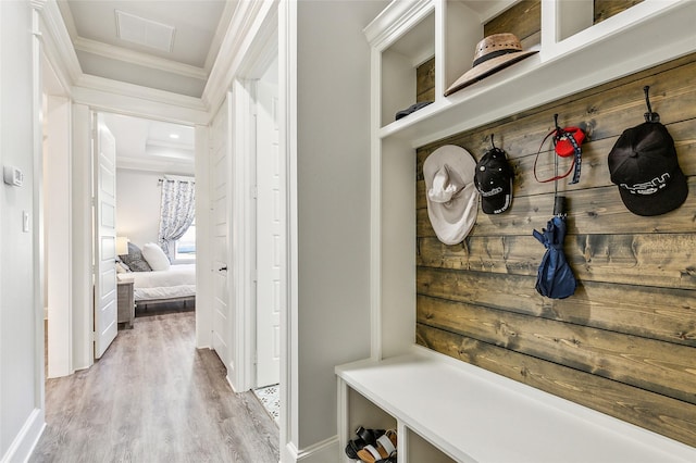 mudroom with visible vents, light wood-style flooring, baseboards, and ornamental molding