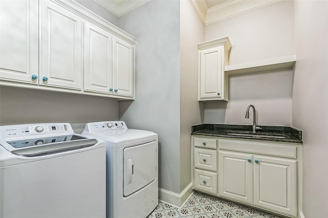 clothes washing area with crown molding, baseboards, cabinet space, independent washer and dryer, and a sink