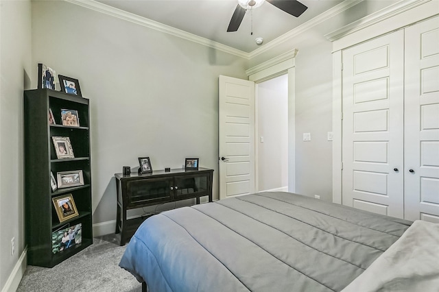 bedroom with a ceiling fan, baseboards, carpet floors, ornamental molding, and a closet