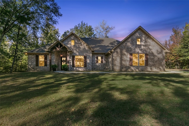 view of front facade with a yard and brick siding