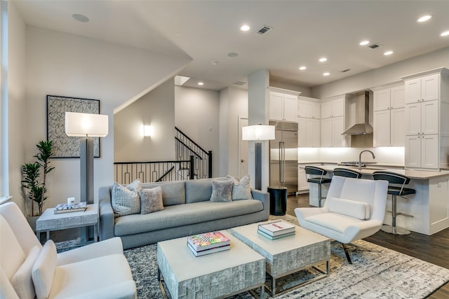 living area featuring recessed lighting, visible vents, dark wood finished floors, and stairway