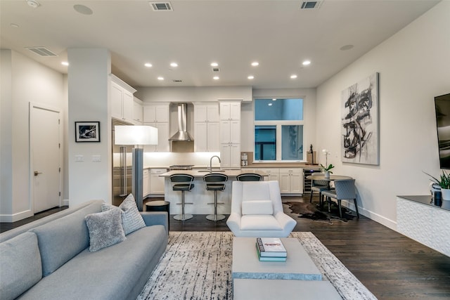 living area featuring dark wood-type flooring, recessed lighting, visible vents, and baseboards