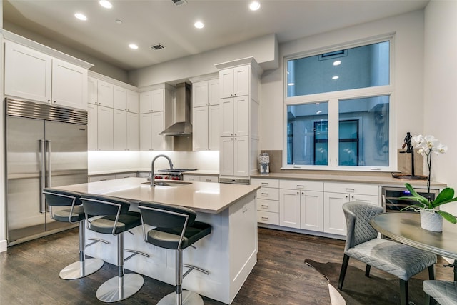 2324 Centurion Ct, Dallas, TX 75204 - kitchen with built in refrigerator, wall chimney range hood, dark wood-type flooring, white cabinetry, and recessed lighting