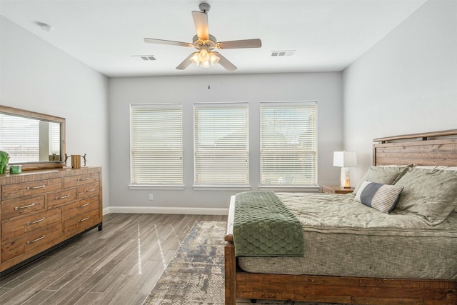 bedroom with visible vents, multiple windows, baseboards, and wood finished floors