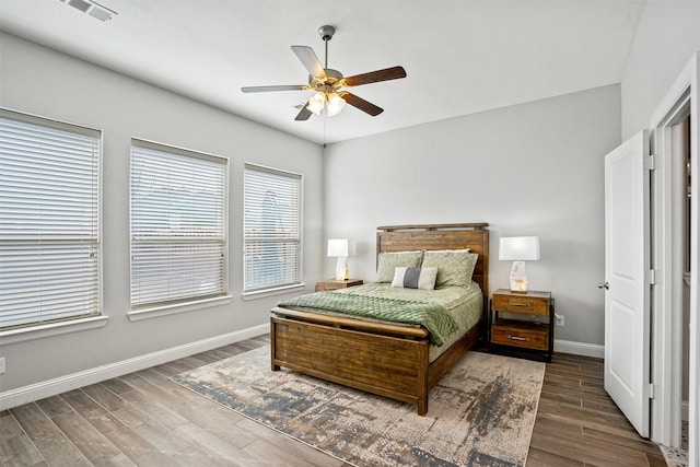 bedroom with visible vents, baseboards, wood finished floors, and a ceiling fan