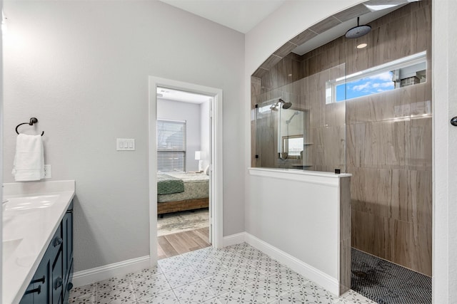 ensuite bathroom featuring baseboards, ensuite bath, vanity, and a walk in shower