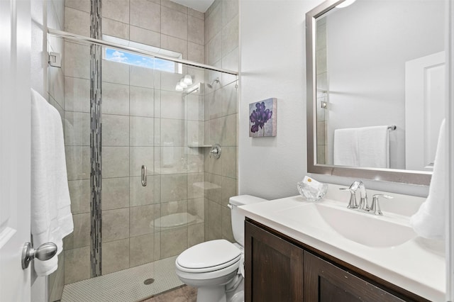 bathroom with toilet, a stall shower, and vanity