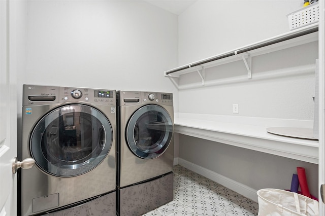 washroom featuring washer and dryer, baseboards, and laundry area