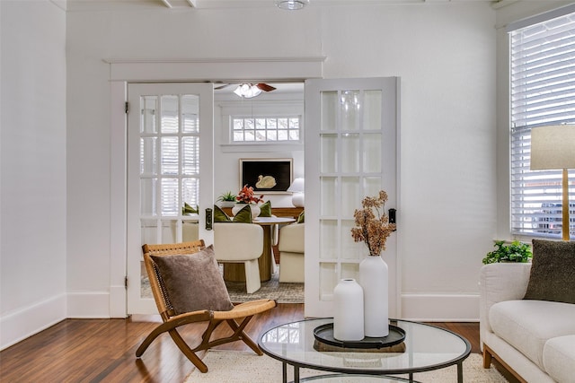 living area with a wealth of natural light, baseboards, and wood finished floors